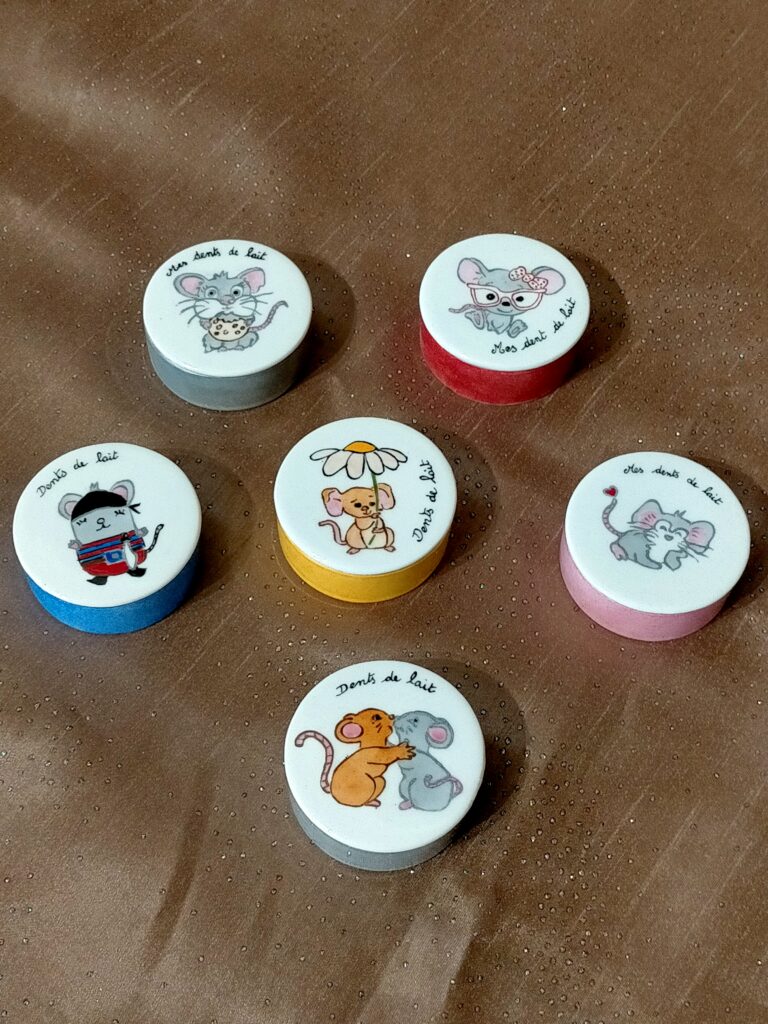 Cette photo montre divers boîtes à dent de lait décorées de mignonnes petites souris en couleurs